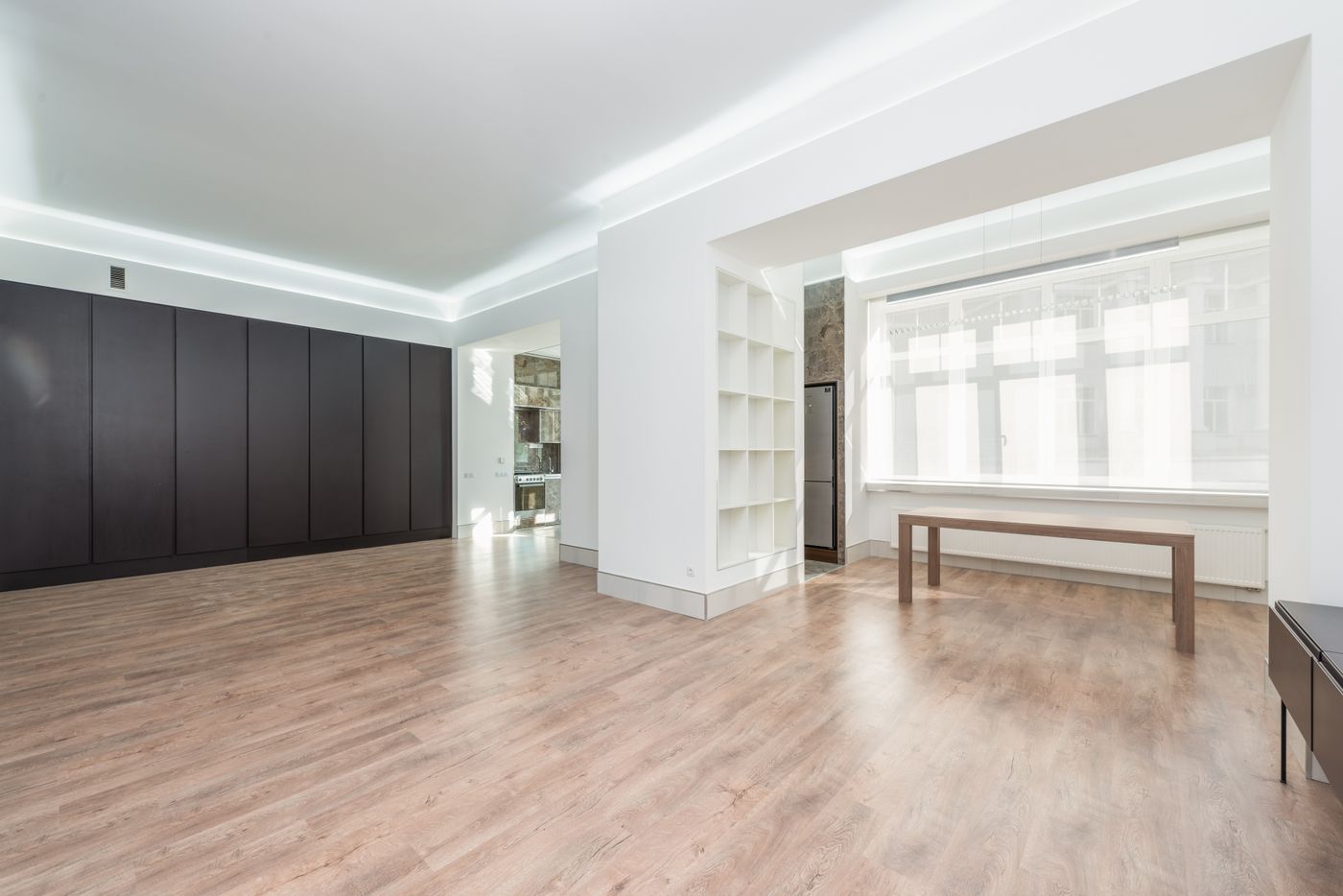 A bright, empty room with a pale wood floor in a Fairview home.